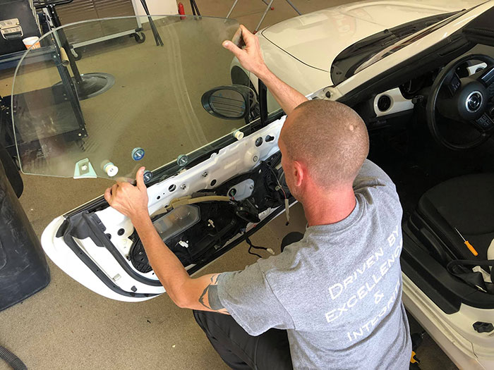 Man Replacing the rear and side windows of a car
