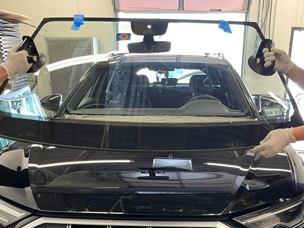 Men doing an in-shop windshield replacement